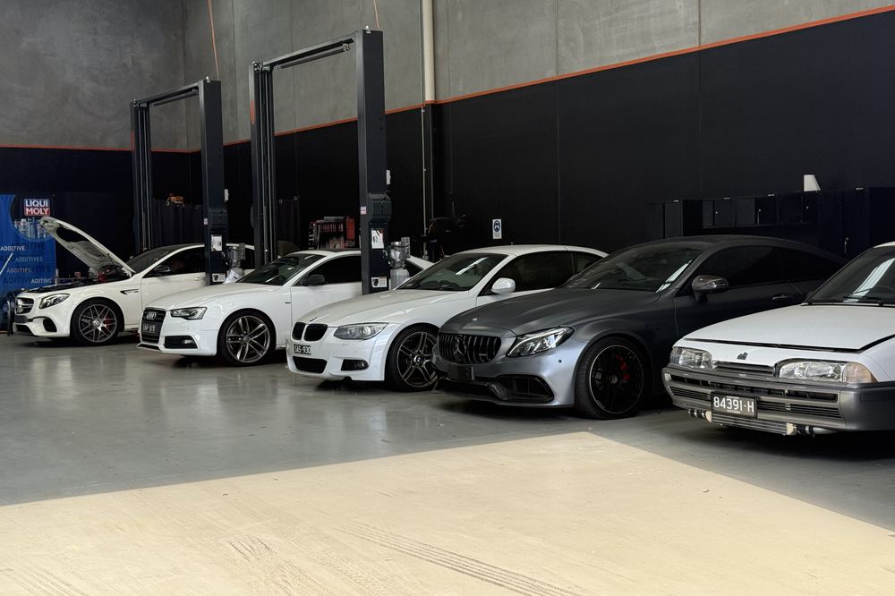 Wide view of the Ignition Autohaus workshop floor, hoists and a row of European cars